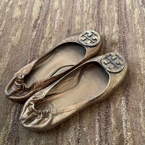Tory Burch copper metallic flats with gold matte pendant